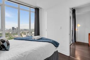 a bedroom with a bed with a large window at Downtown Condo - Free Parking/Self Check-in in Toronto