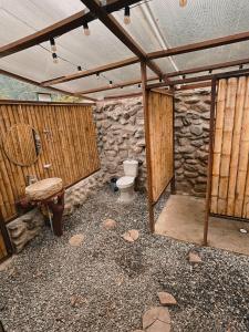 a bathroom with a toilet and a stone wall at Glampling Dos Quebradas in Floridablanca