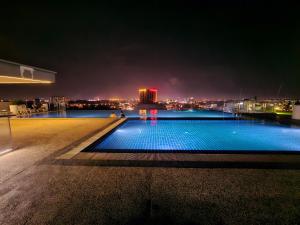 una piscina en la azotea de un edificio por la noche en Lovely Kozi Square comfort Studio Home 3D, en Kuching