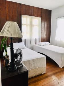 a bedroom with two beds and a lamp on a table at Avong Nen Kitma in Baguio
