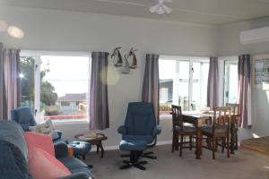 a living room with a couch and a table and chairs at Jacks place in Moeraki