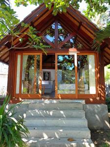 龍目島的住宿－Bintang Tiga Bungalows Gili Air，一座小房子,设有玻璃窗和楼梯