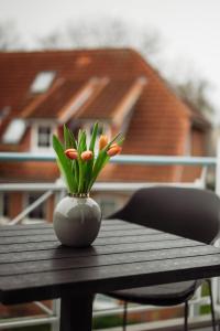 un vaso con fiori su un tavolo di legno di App Ostseebrise a Timmendorfer Strand