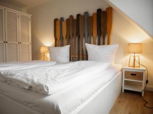 una camera da letto con un grande letto bianco con due lampade di App Ostseebrise a Timmendorfer Strand