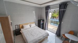 胡志明市的住宿－Marki Home 2，一间卧室设有一张床、一个窗口和一张桌子