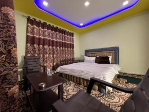 a room with a bed and a table and a chair at GUREZ GUEST HOUSE in Kanzalwan