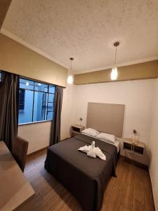 Una habitación de hotel con una cama con una bata. en Hotel Palace Puebla en Puebla