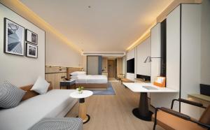 um quarto de hotel com uma cama e uma secretária em Four Points by Sheraton Chengdu, High-Tech Zone Exhibition Center em Chengdu