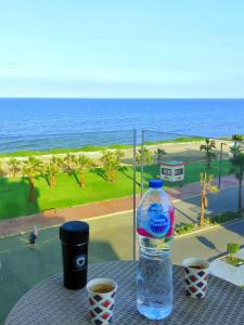 una botella de agua en una mesa con vistas al océano en Porto Said شاليه ملكى صف اول بحر بورتو سعيد, en Puerto Saíd
