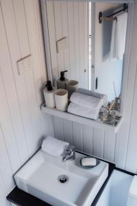 W łazience znajduje się biała umywalka i lustro. w obiekcie Djindarup Retreat 1 w mieście Prevelly