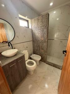 y baño con aseo, lavabo y ducha. en Chajari Suites en Chajarí