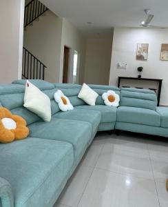 a blue couch with stuffed animals on it in a living room at Fourteen Homestay in Port Dickson