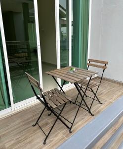 a wooden table and a chair on a balcony at Fourteen Homestay in Port Dickson