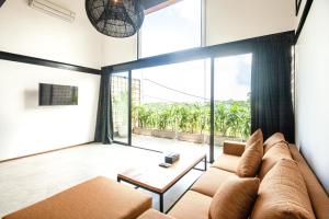 a living room with a couch and a large window at Spacious Loft 200m From Canggu Beach in Canggu