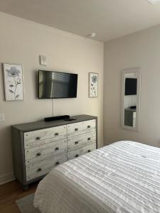 a bedroom with a bed and a television on a dresser at Devine living in the med center in Houston