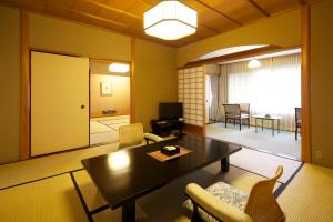 sala de estar con mesa y sillas en Hanzuiryo en Unzen