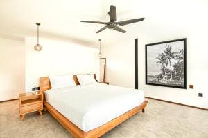 a bedroom with a bed and a ceiling fan at Spacious Loft 200m From Canggu Beach in Canggu