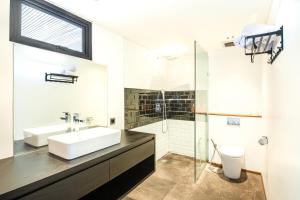 a bathroom with a sink and a glass shower at Expansive Loft 200m From Canggu Beach Haven in Canggu