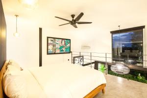 a bedroom with a bed and a ceiling fan at Modern Duplex 200m From Canggu Blissful Beach in Canggu