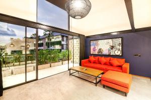 a living room with a red couch and a table at Modern Spacious Loft 200m From The Beach Canggu in Canggu