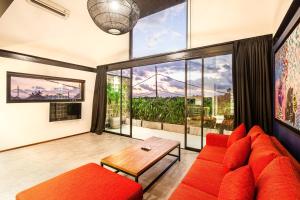 - un salon avec un canapé rouge et une table dans l'établissement Contemporary Loft 200m From Canggu Shoreline, à Canggu