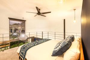 a bedroom with a bed and a ceiling fan at Modern Spacious Loft 200m From The Beach Canggu in Canggu