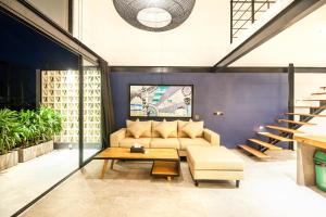 a living room with a couch and a table at Lofty Nyc Vibes 200m To Canggu Beach in Canggu +15 photos