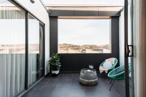 a balcony with a table and chairs and windows at Change Overnight in Launceston