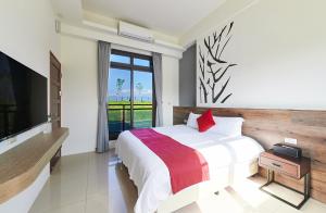 a bedroom with a large bed and a television at Xiangyue 38 Homestay in Dongshan