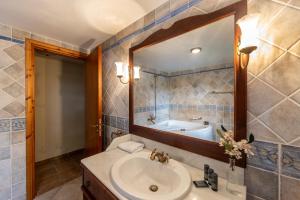 a bathroom with a sink and a mirror and a tub at Troodos Mature Pine Chalet in Pedoulas +31 photos