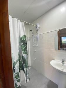 a bathroom with a shower curtain and a sink at Buona Vita resort in Panglao