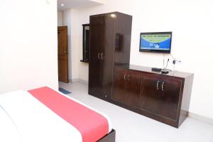 una camera con letto e TV a parete di hotel dreamland a Haridwār