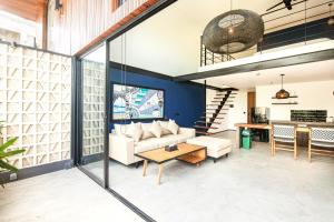 a living room with a couch and a table at Modern Duplex 200m From Canggu Blissful Beach in Canggu