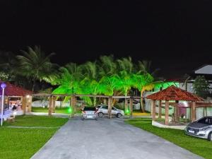 a group of palm trees in a yard at night at Pousada Villa do Mar in Itaparica