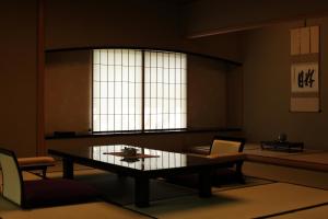 a living room with a table and chairs and a window at Hanzuiryo in Unzen