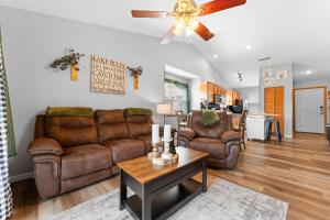 a living room with leather furniture and a ceiling fan at Lizzy's Landing in Branson