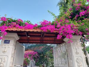 een bos bloemen op een boog boven een hek bij Nha Xanh Homestay in Ninh Binh