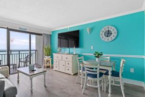 a living room with a blue wall and a table with chairs at Oceanfront Oasis in Myrtle Beach