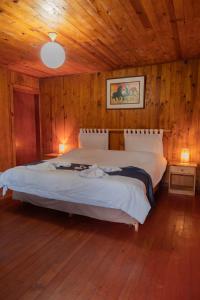 オクサパンパにあるCabañas Palma Sky Lodgeの木製の壁のベッドルーム1室(ベッド2台付)