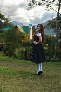 a young girl is standing in the grass at Cabañas Palma Sky Lodge in Oxapampa