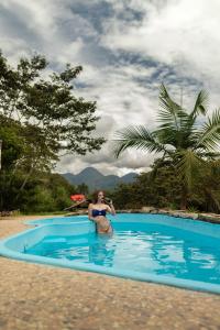 una mujer en bikini sentada en una piscina en Cabañas Palma Sky Lodge en Oxapampa