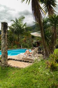 奧克薩潘帕的住宿－Cabañas Palma Sky Lodge，坐在游泳池旁椅子上的女人