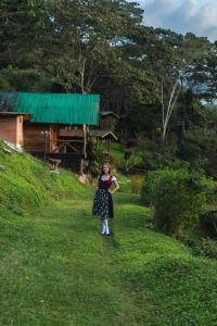 a woman walking down a path in the grass at Cabañas Palma Sky Lodge in Oxapampa