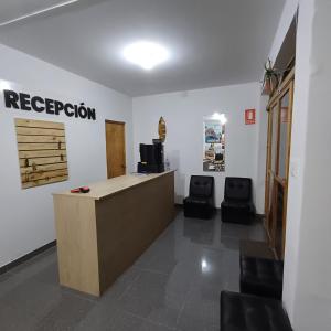 a reception room with a reception desk and two chairs at El Capricho Paracas in Paracas