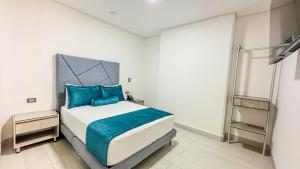 1 dormitorio con 1 cama grande con almohadas azules en Hotel Marco Polo Rodadero, en Santa Marta