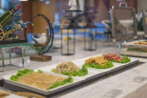 um buffet com três pratos de comida numa mesa em Holiday Inn Express Qingdao Chengyang Central, an IHG Hotel em Qingdao