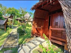 Cabaña pequeña con techo de hierba en Orangutan Bungalow, en Bukit Lawang