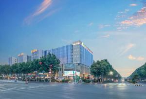 a large glass building on a city street at Holiday Inn Express Qingdao Chengyang Central, an IHG Hotel in Qingdao