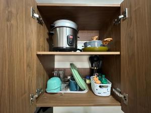 a cupboard with food and utensils in it at Lapu-Lapu City Condo in Lapu Lapu City