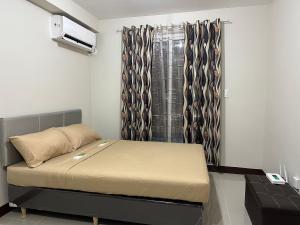 a small bedroom with a bed and a window at Lapu-Lapu City Condo in Lapu Lapu City +23 photos